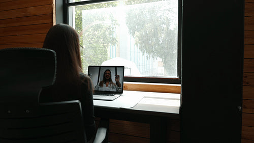Remote work in a coworking space: Young business woman having an online meeting with her remote team