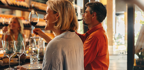 Group of friends enjoying a wine tasting at a boutique wine shop, sitting around a table with glasses