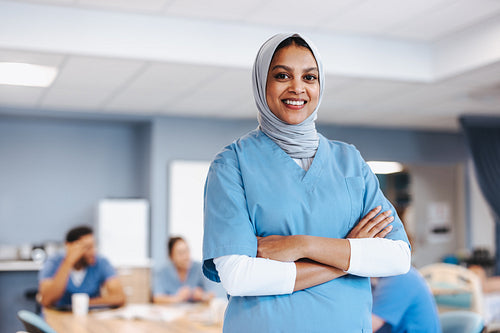 Student wearing a hijab and medical scrubs in a hospital ward