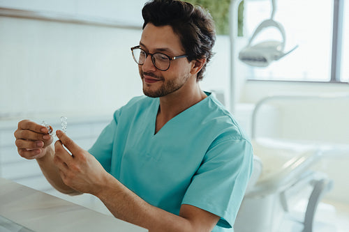 Orthodontist examines clear aligners in a clinic setting