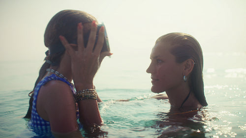 Mother and daughter share a loving kiss during a luxurious family vacation at a tropical resort