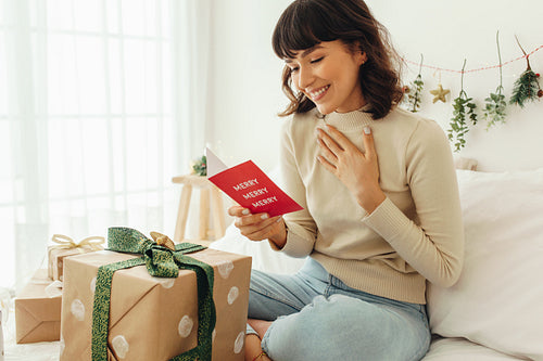 Happy woman reading a christmas greeting card