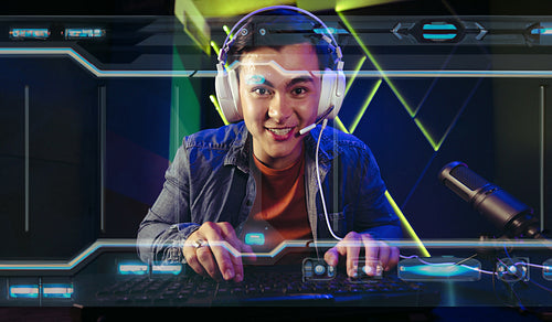 Engaged in an exciting first person shooter video game, a male gamer sits in front of a computer screen