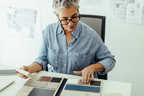 Female interior design expert carefully selects colour swatches for her next design