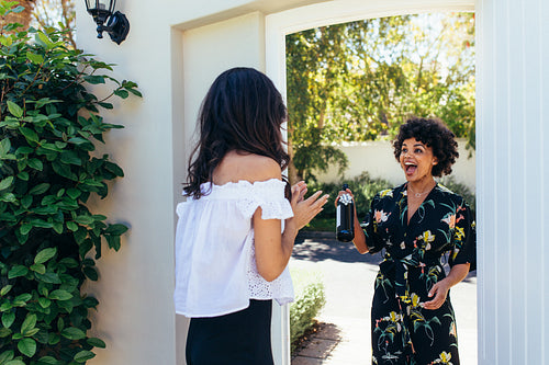 Excited woman with wine bottle for housewarming party