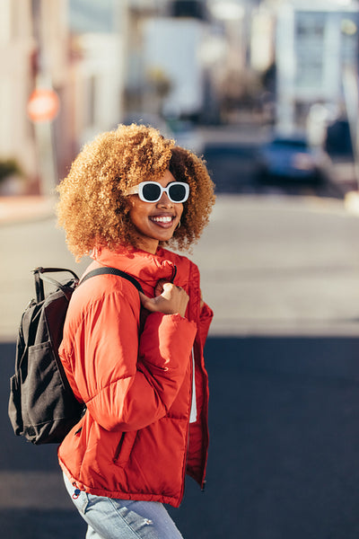 Cheerful woman traveller walking on street