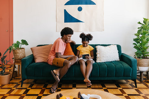 Connected family living: Kids relaxing on a sofa with a touchscreen tablet