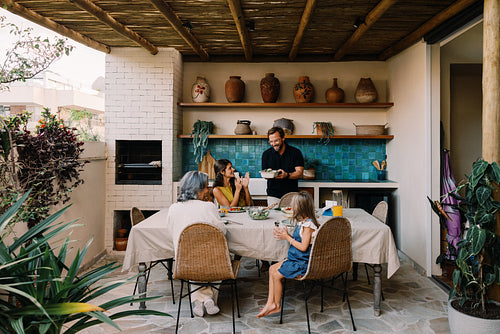 Family dinner on outdoor kitchen terrace