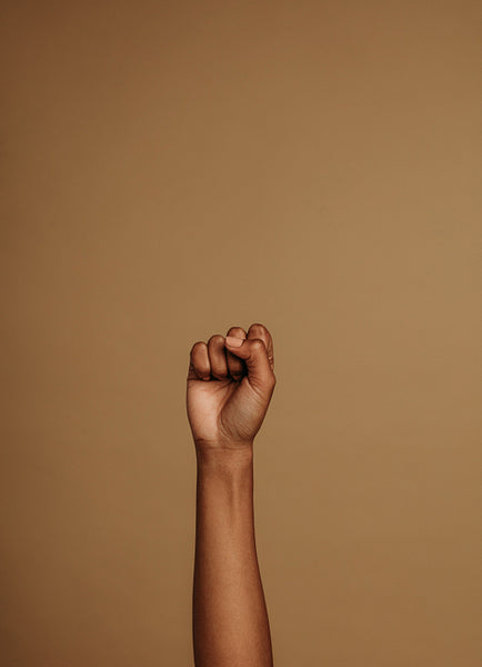 Raised hand on brown background