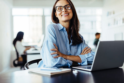 Female web developer sitting with a laptop in an office