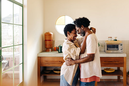 Lovebirds at home: Mature couple holding each other close