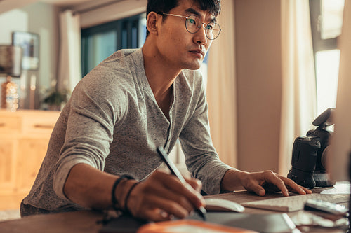 Concentrated photo editor working in his studio