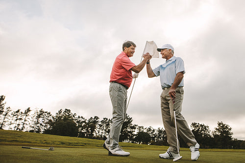 Golfers shaking hands at golf course after the game