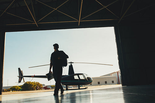  Helicopter pilot arriving at airplane hangar