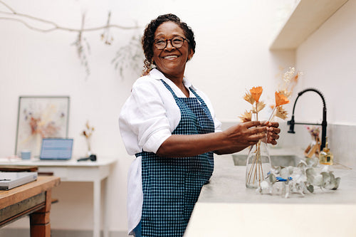 Floral handicraft: Senior woman creating a bouquet of dry flowers