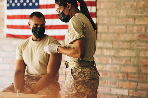 Doctor preparing to administer the covid-19 vaccine to a soldier