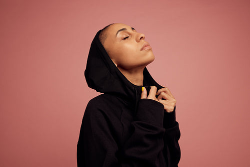 Androgynous woman in black hoodie jacket