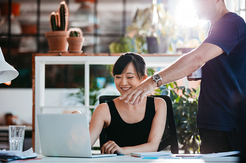 Two young executives working together on laptop