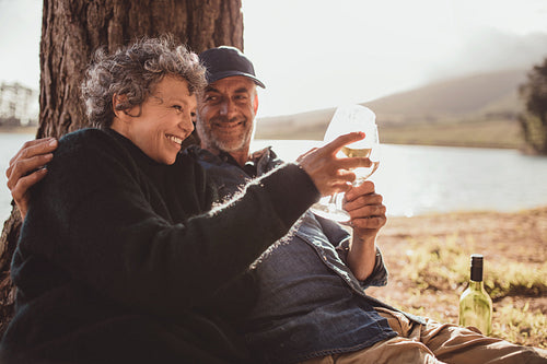 Senior couple drinking wine at campsite.