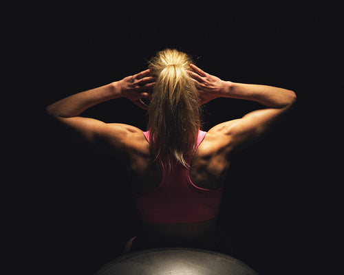 Woman Lying on Fitness Ball and Doing Sit Ups