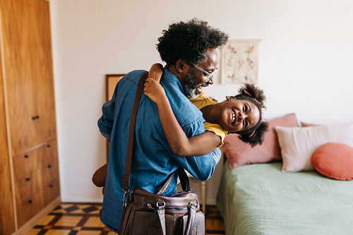 Happy father carrying his daughter after work
