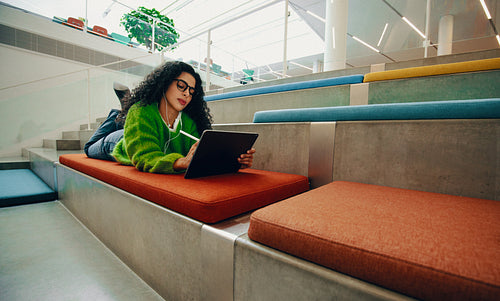 Creative woman works on a tablet in a public library learning space