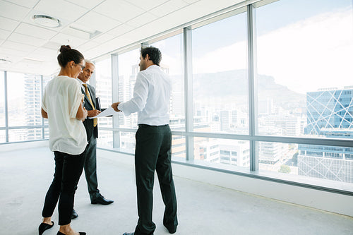 Real estate agent talking with potential clients at new office space