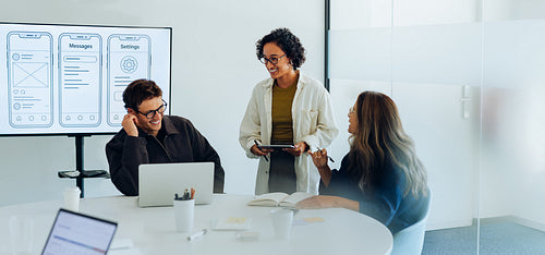 Three designers sketch ideas during UX team meeting
