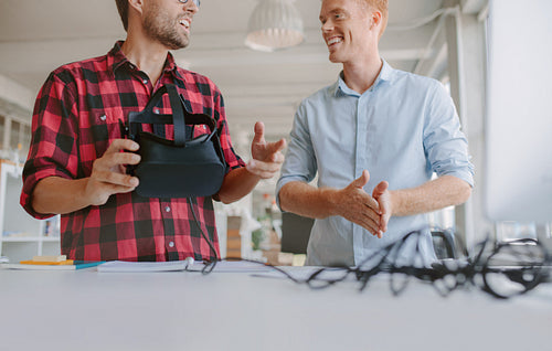 Business men discussing and testing VR glasses.