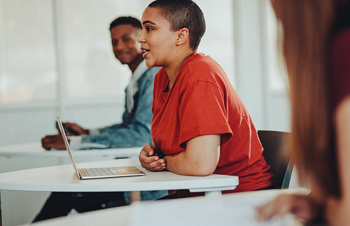 Student talking with lecturer in classroom