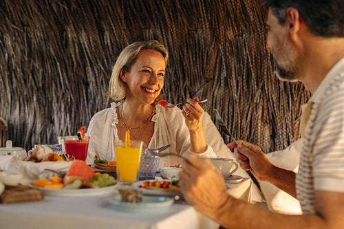Happy couple enjoying luxury holiday breakfast together in an outdoor setting