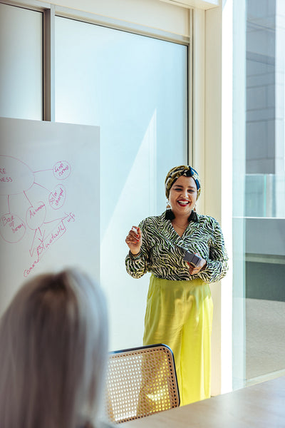 Confident Indian woman leading a business presentation in a modern office with bright natural light