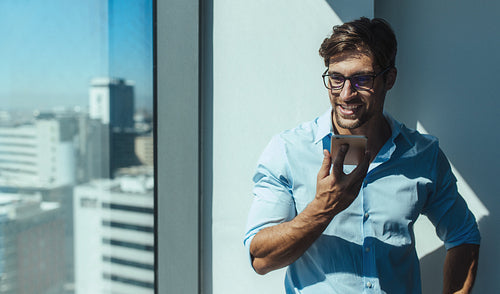 Businessman talking on mobile phone in office.