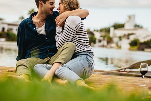 Couple sitting outdoors near a lake in a romantic mood