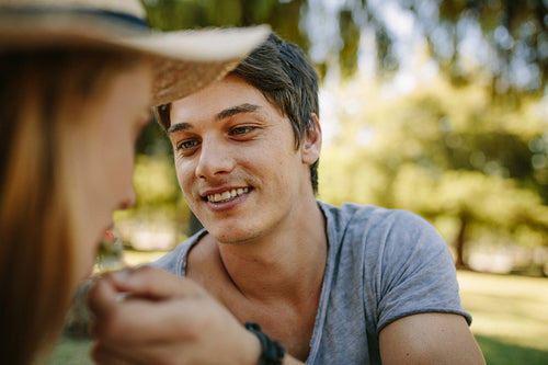 Close up of a man feeding picnic to his girlfriend
