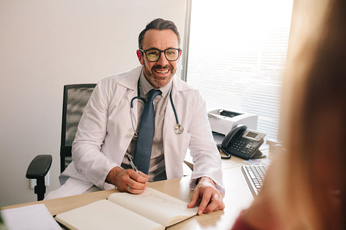 Doctor talking with patient in his clinic