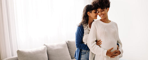 Expectant lesbian couple bonding at home