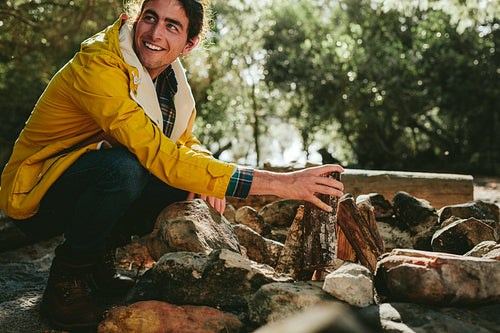 Man camping in the countryside making a bonfire