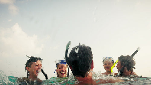 Happy family snorkeling together in the beautiful clear turquoise ocean
