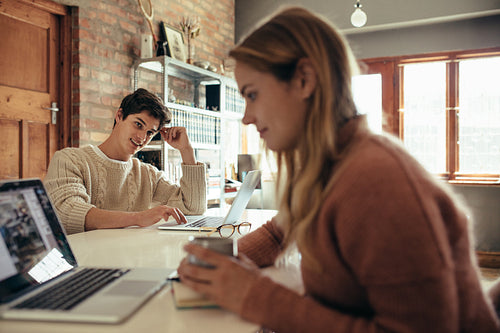 Man sitting at table and looking at his girlfriend