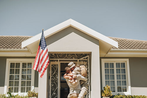 Cheerful female soldier reunitng with her husband at home