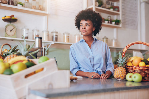 Confident young female juice bar employee