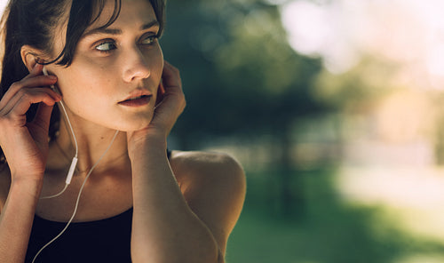 Sportswoman with earphones looking away