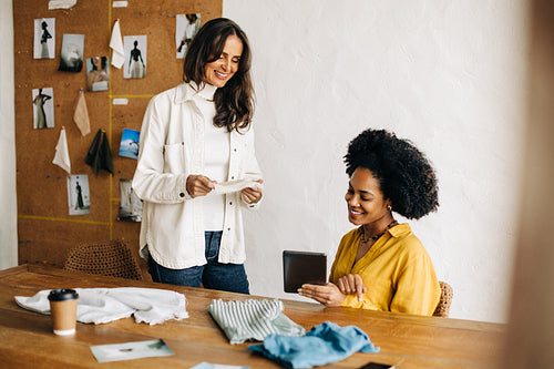 Successful clothing designers presenting a fabric sample on a video call