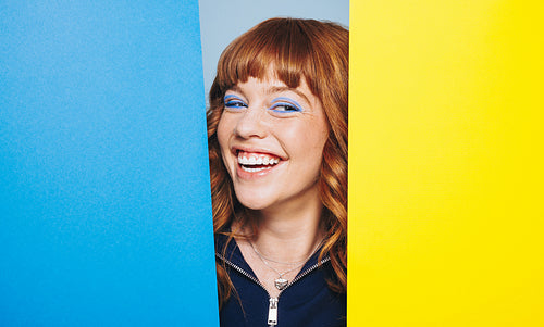Happy woman standing with design shapes in a studio