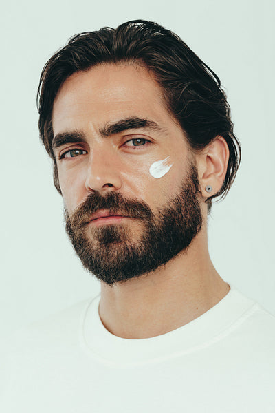 Embracing male skincare with confidence, man applying moisturizing beauty cream on his face