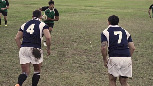 Rugby players tackling during game