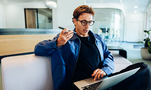 Businessman with laptop and phone in coworking space