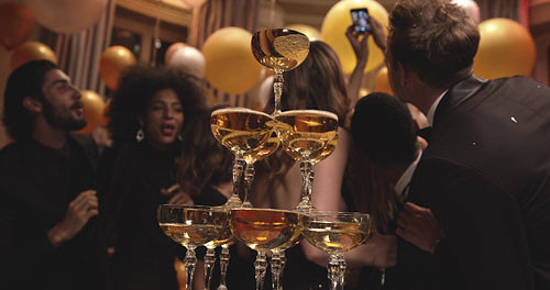 Party people taking selfie with pyramid of champagne glasses