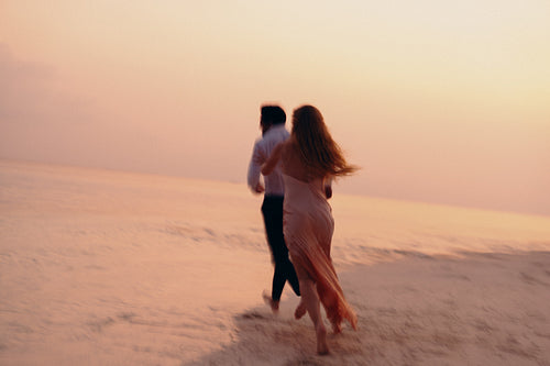 Tropical tranquility: Playful couple cherishing romantic honeymoon sunset